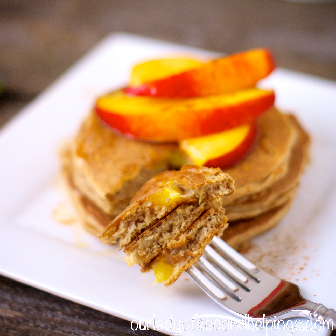 Spiced Oatmeal Buttermilk Pancakes with Nectarines Plate of pancakes with nectarine slices
