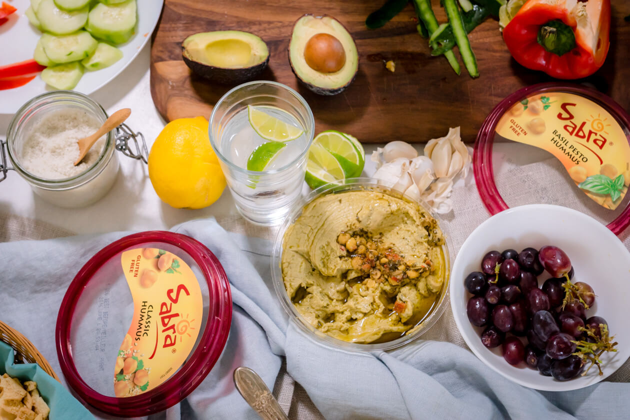 Give hummus a quick and easy makeover with an avocado-lime hummus topping. Perfect easy appetizer, tailgate food, or healthy snack recipe.