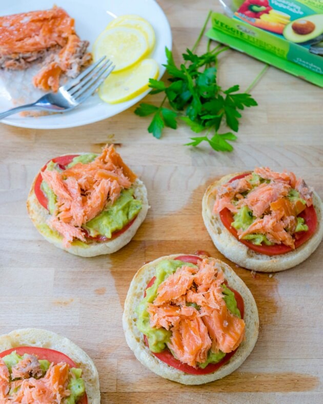 Avocado toast with smoked salmon on crisp toasted English muffins topped with tomato, Sabra's new Veggie Fusions guacamole + veggies is the perfect healthy lunch for busy days.