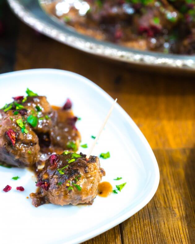 Tender cranberry glazed meatballs dotted with dried cranberries & fresh parsley, pan seared, then simmered in a sweet-tart cranberry glaze.